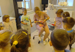 Pani doktor wyjaśnia zasady prawidłowego szczotkowania zębów.