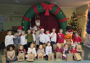 Grupowe zdjęcie dzieci z Mikołajem.