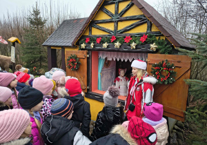 Dzieci oglądają chatkę babci z bajki pt. Czerwony Kapturek.