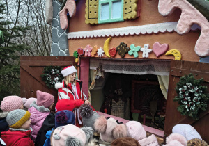 Dzieci oglądają chatkę z bajki Jaś i Małgosia.