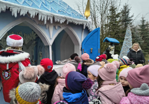 Dzieci oglądają chatkę z bajki Królowej Śniegu.