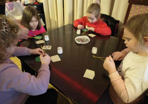 Dzieci podczas warsztatów wykonują bombki.