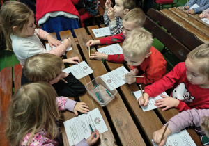 Dzieci wypełniają Kartki Zapomnienia na których wypisują złe uczynki.