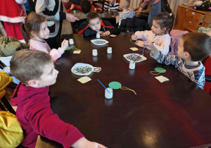 Dzieci z grupy Motylków na warsztatach wykonują bombki.