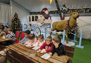 Dzieci z grupy Motylków wypełniają kartki zapomnienia.