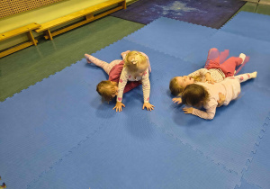 Dzieci turlają się w parach.