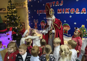 Święty Mikołaj rozmawia z dziećmi.