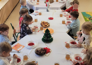 Dzieci rozpoczynają jedzenie świątecznych potraw.