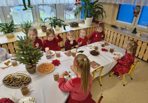 Dzieci jedzą pierogi.