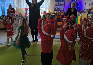 Dzieci naśladują migoczące gwiazdeczki rękami.