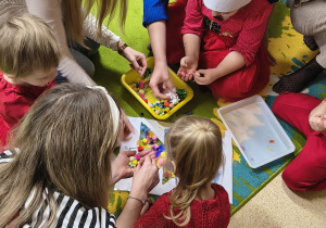 Zabawa plastyczna - wspólne ozdabianie choinki piórkami i pomponami.
