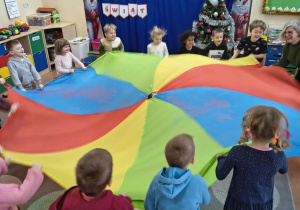 Podrzucanie papierowych kulek - śnieżynek na chuście animacyjnej.