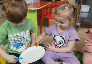 Dzieci uczestniczą w zabawie ze spinaczami.