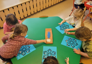 Dzieci wykonują pracę o tematyce zimowej.