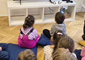 Dzieci oglądają bajkę “Zaczarowany ołówek”.