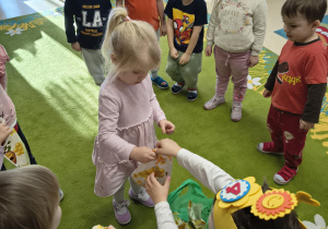 Dziewczynka odbiera pprezent od Wiktora.