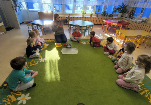 Nauczycielka pokazuje dzieciom foremki do babeczek.