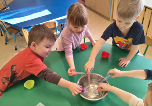 Dzieci nabierają wody do pipetek.