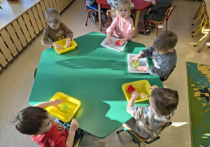 Dzieci wyciągają lodowe babeczki z foremek.