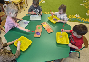 Dzieci barwią farbą lodowe babeczki.