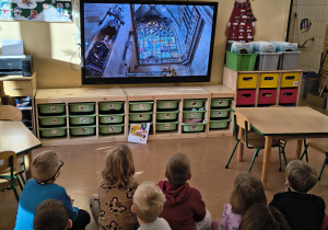 Dzieci oglądają film o tym jak powstają witraże.