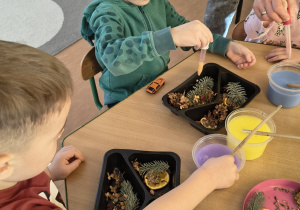 Dzieci tworzą lodowe witraże.