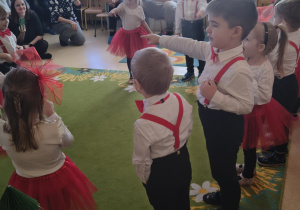 Dzieci śpiewają piosenkę dla babci i dziadka pt. "Koci koci łapci".