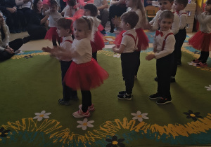 Dzieci uczestniczą w zabawie do piosenki pt. "Sanki w bok".