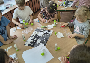 Dzieci łączą elementy za pomocą kleju.