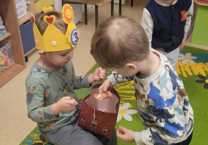 Chłopiec częstuje się cukierkiem.