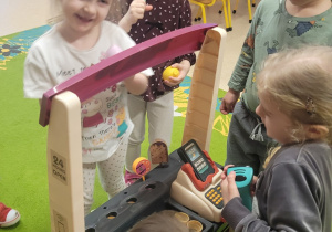 Dziewczynka naśladuje kupowanie soku.