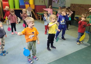 Dzieci uczestniczą w zabawach z papierowymi balonami.