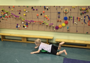 Chlopiec jeździ na deskorolce terapeutycznej.