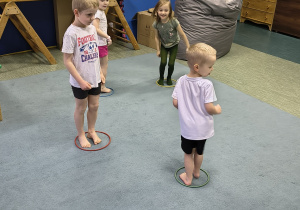 Chłopcy stoją na dywanie w obręczy.