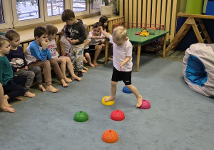 Chłopiec ćwiczy równowagę przechodząc przez tor przeszkód.