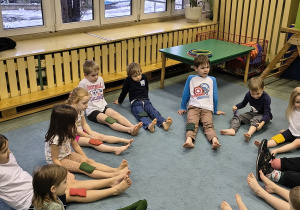 Dzieci siedzą w kręgu z woreczkami.