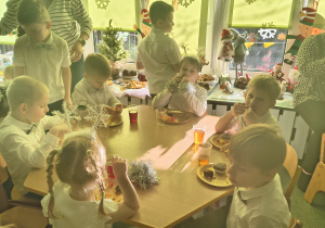 Dzieci uczestniczą w świątecznym poczęstunku.