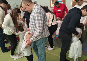 Dzieci tańczą z rodzicami taniec świąteczny.