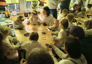 Dzieci wraz z rodzicami wydrapują kolorowe bombki.