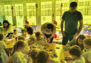 Dzieci z grupy Biedronek siedzą przy stole podczas pracy plastycznej.