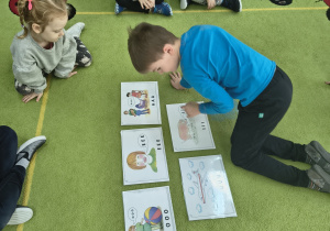 Chłopiec z grupy Biedronek czyta samogłoski, które są na obrazku.