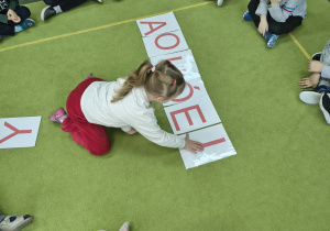 Dziewczynka układa samogłoski.