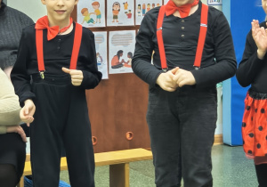 Chłopcy stojąc recytują wiersz dla zebranych gości.