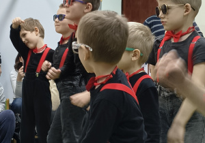 Chłopcy tańczą taniec dla babci i dziadka.