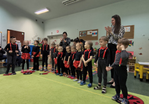 Dzieci wraz z nauczycielkami śpiewają sto lat dla babci i dziadka.