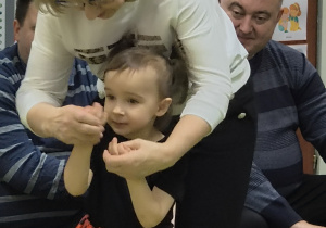 Dziewczynka pokazuje wybraną bajkę w zabawie w kalambury.