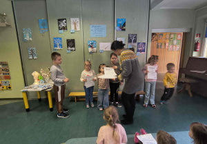 Dzieci z grupy Biedronek odbierają dyplomy za udział w konkursie plastycznym.