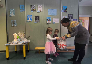 Dziewczynki z grupy Pszczółki odbierają nagrody i dyplomy za udział w konkursie plastycznym.