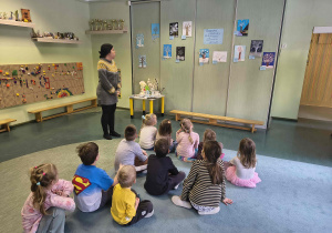 Nauczyciel omawia z dziećmi wykonane prace plastyczne.