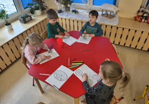 Dzieci usprawniają mięśnie palców i dłoni podczas kolorowania.